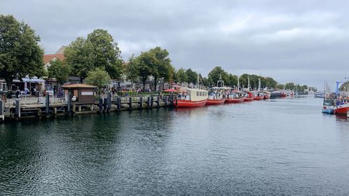 Boats moored in river against sky