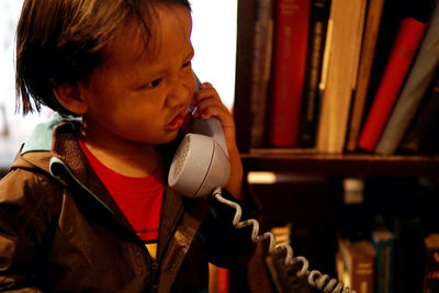 Close-up of boy talking on landline phone