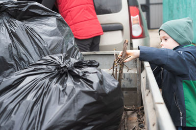 Child collects dry sticks in the trailer to take out with other garbage. 