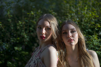 Portrait of beautiful friends standing in park