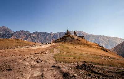 Scenic view of arid landscape against clear blue sky