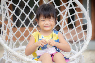 Portrait of cute girl sitting outdoors