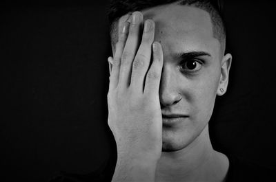 Close-up portrait of young man against black background