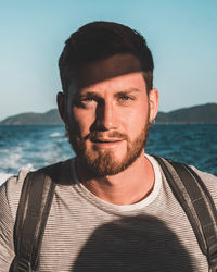 Portrait of young man against sea against sky