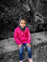 Portrait of cute girl sitting outdoors