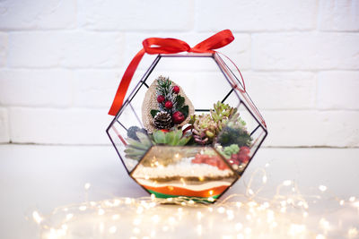 Close-up of red flower in glass container on table