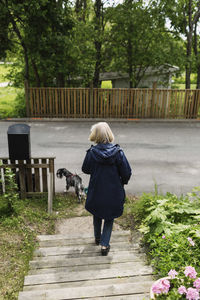 Rear view of woman walking on footpath