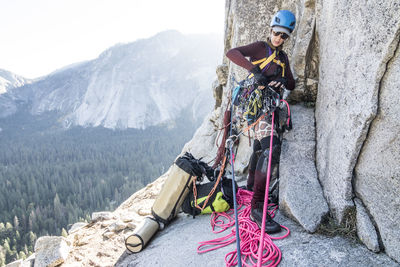 A young woman climber checks her gear one last time before setting out