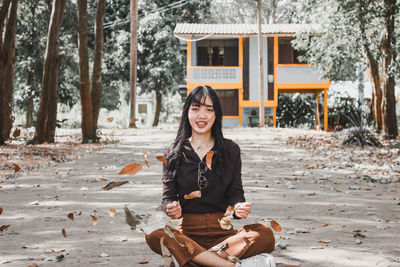 Portrait of smiling young woman sitting outdoors
