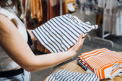 Modern latina young woman choosing 100 percent organic cotton wear t shirt in modern eco-friendly