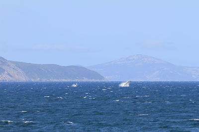 Scenic view of sea and mountains against sky