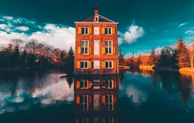 Reflection of building in lake against sky