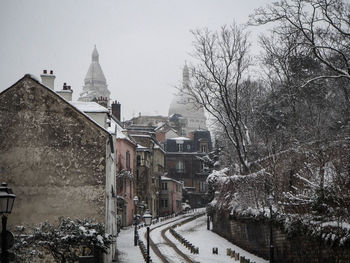 Buildings in city against sky during winter