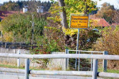 Information sign by plants on fence