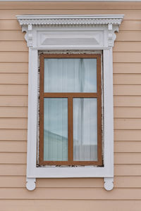 Typical timber window with carved architraves facade of 19th century residential building, russia