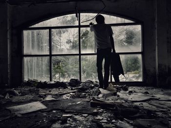 Rear view of man standing in abandoned house