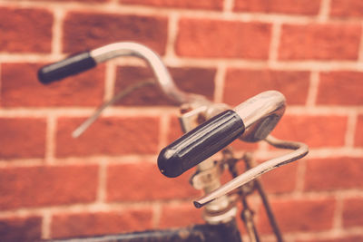 Close-up of bicycle against brick wall