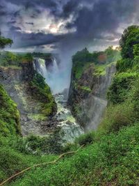 Scenic view of waterfall against sky