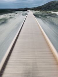 Surface level of pier on sea against sky