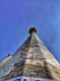 Low angle view of tower against blue sky