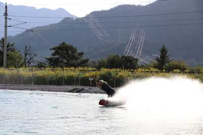 Scenic view of tree by mountain against sky