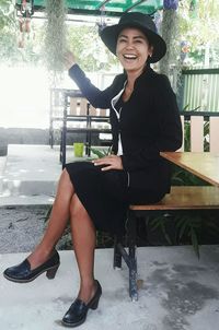 Portrait of smiling young woman sitting outdoors