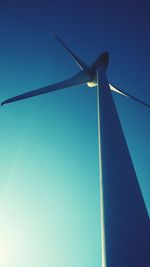 Low angle view of wind turbine against blue sky