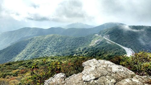 Scenic view of mountains against cloudy sky