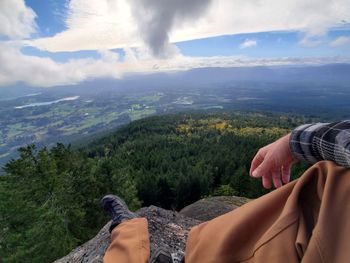 Midsection of man looking at mountain range against sky