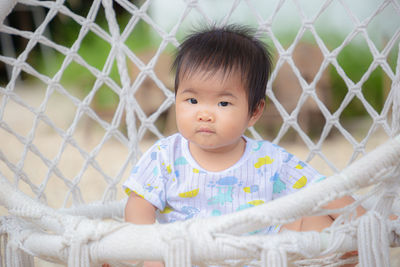 Portrait of cute baby boy fence