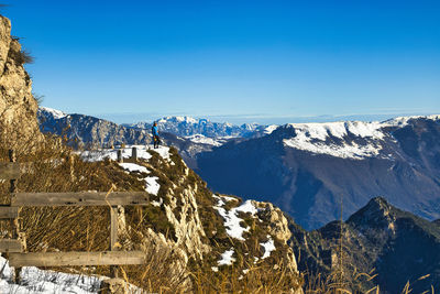 Panoramic view of snowcapped mountains against clear blue sky