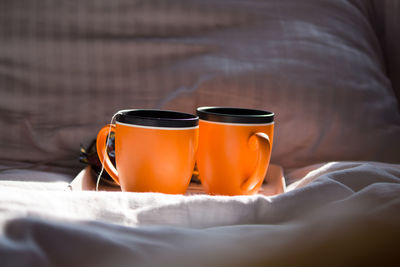 Close-up of tea cup on bed