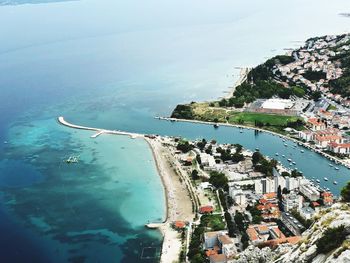 Aerial view of buildings by sea against sky