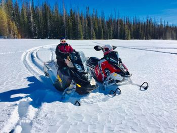 View of people riding motorcycle on snow