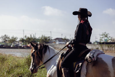 Cowgirl horseback riding, woman on horse at sunset