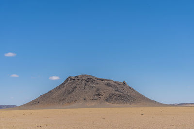 Scenic view of desert against clear blue sky