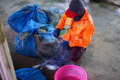 High angle view of man working with fishing net