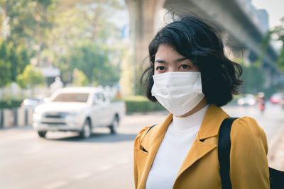 Close-up of woman wearing mask looking away while standing outdoors