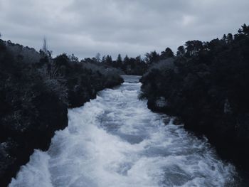 Scenic view of river against cloudy sky