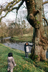 Rear view of couple standing on tree trunk