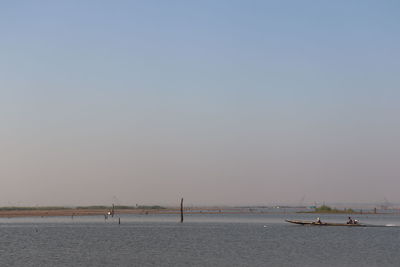 Sailboats sailing in sea against clear sky