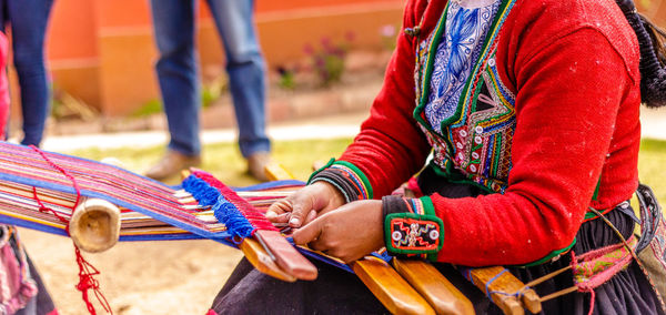 Close-up of woman hands weaving wool