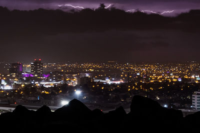 High angle view of city lit up at night