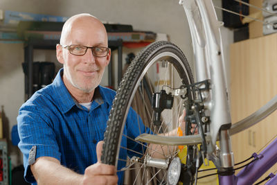 Mature man repairing bicycle in garage