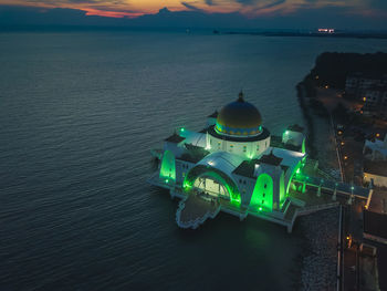 High angle view of illuminated sea against sky at sunset