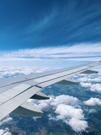 Aerial view of aircraft wing against blue sky