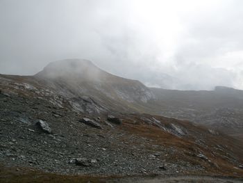 Scenic view of mountains against cloudy sky