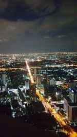 Illuminated cityscape against sky at night