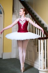 Woman in tutu dancing at home