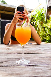 Woman photographing drink on table